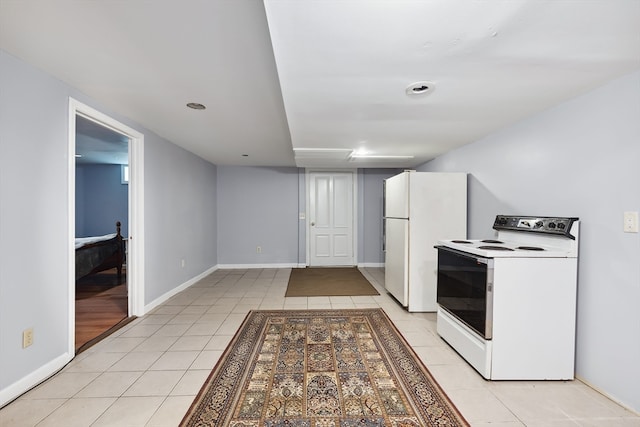 kitchen featuring white appliances, light tile patterned floors, and white cabinetry