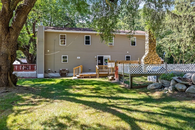 rear view of property featuring a yard and a wooden deck