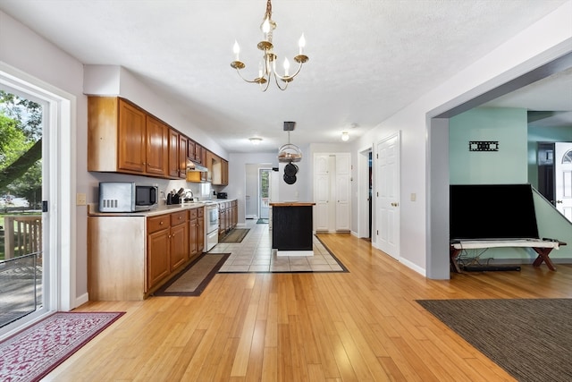 kitchen with a center island, decorative light fixtures, light hardwood / wood-style floors, a notable chandelier, and electric stove