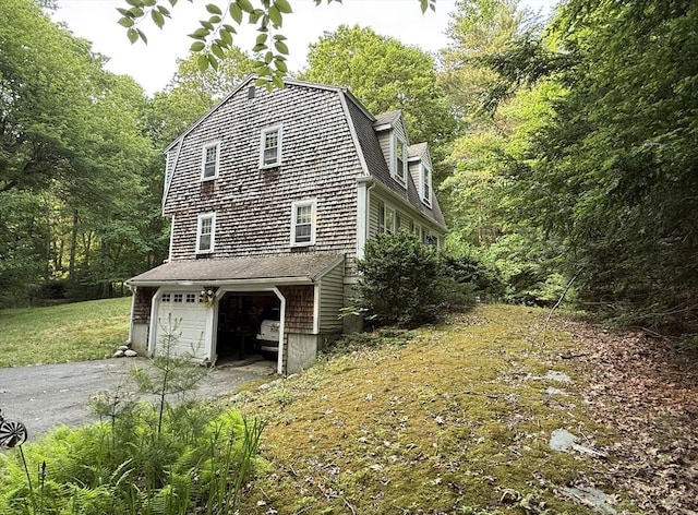 270 Pine St, Marshfield, MA 02050 - view of home's exterior featuring asphalt driveway, a gambrel roof, a garage, and a view of trees