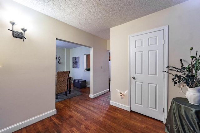 hallway featuring dark hardwood / wood-style floors and a textured ceiling