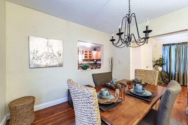 dining space featuring an inviting chandelier, dark hardwood / wood-style floors, and a textured ceiling