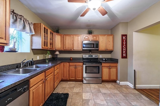 kitchen featuring stainless steel appliances, light tile patterned flooring, sink, and ceiling fan