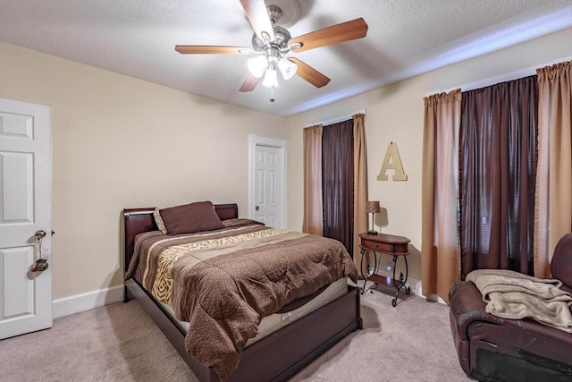 carpeted bedroom with ceiling fan and a textured ceiling