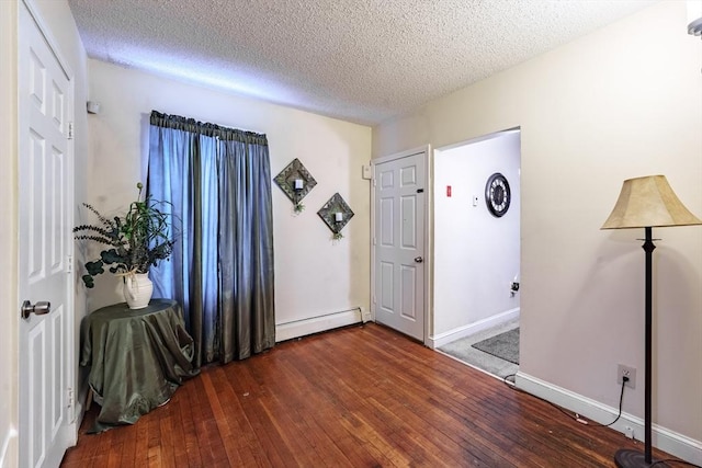 entryway with a baseboard heating unit, dark hardwood / wood-style floors, and a textured ceiling