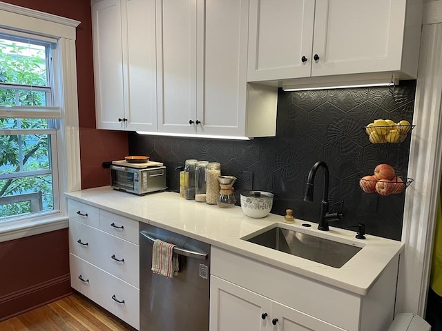 75 Rossmore Rd Unit 5, Boston, MA 02130 - kitchen featuring stainless steel dishwasher, tasteful backsplash, white cabinets, wood finished floors, and light stone counters