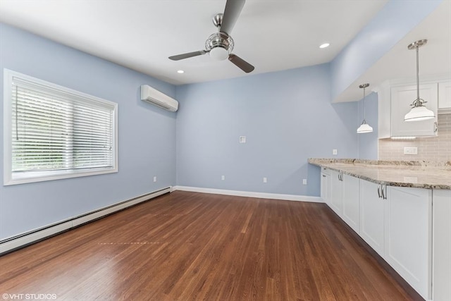 591 Poplar St, Boston, MA 02131 - kitchen with an AC wall unit, baseboard heating, dark wood-style flooring, ceiling fan, and white cabinetry