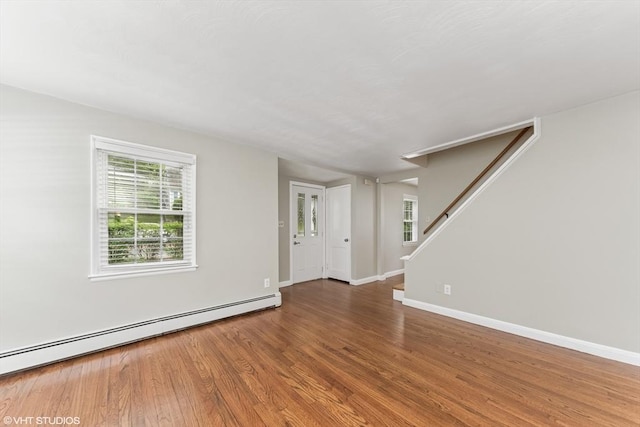 591 Poplar St, Boston, MA 02131 - empty room featuring a baseboard radiator, wood finished floors, plenty of natural light, and baseboards