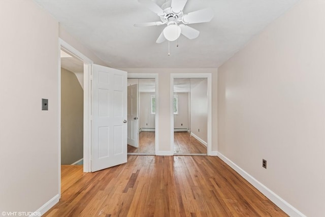 591 Poplar St, Boston, MA 02131 - unfurnished bedroom with light wood-style floors, two closets, baseboards, and a baseboard heating unit