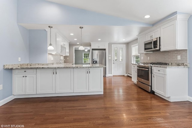 591 Poplar St, Boston, MA 02131 - kitchen featuring appliances with stainless steel finishes, lofted ceiling, a peninsula, dark wood-style floors, and white cabinets