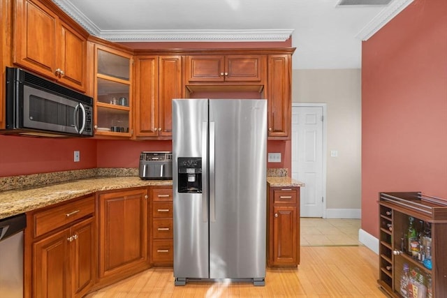 41 Standish St Unit 3, Boston, MA 02124 - kitchen with appliances with stainless steel finishes, brown cabinets, glass insert cabinets, light stone counters, and crown molding