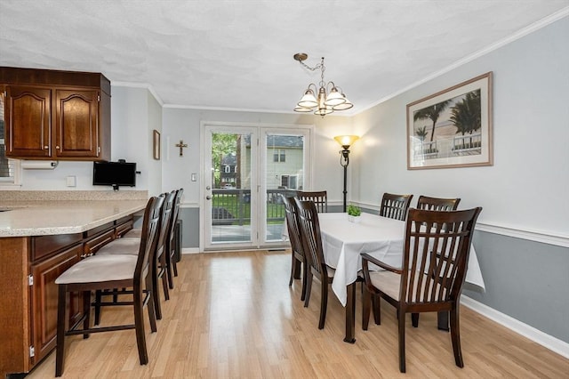 718 Wellman Ave Unit 718, Chelmsford, MA 01863 - dining area with light wood finished floors, ornamental molding, baseboards, and a chandelier
