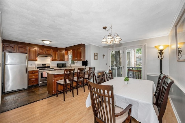 718 Wellman Ave Unit 718, Chelmsford, MA 01863 - dining space featuring ornamental molding, a chandelier, and light wood-style flooring