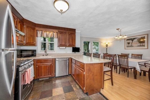 718 Wellman Ave Unit 718, Chelmsford, MA 01863 - kitchen with appliances with stainless steel finishes, a peninsula, a sink, healthy amount of natural light, and a textured ceiling