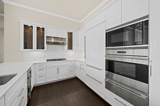 kitchen featuring light stone countertops, white cabinetry, black microwave, wall chimney exhaust hood, and dark hardwood / wood-style flooring