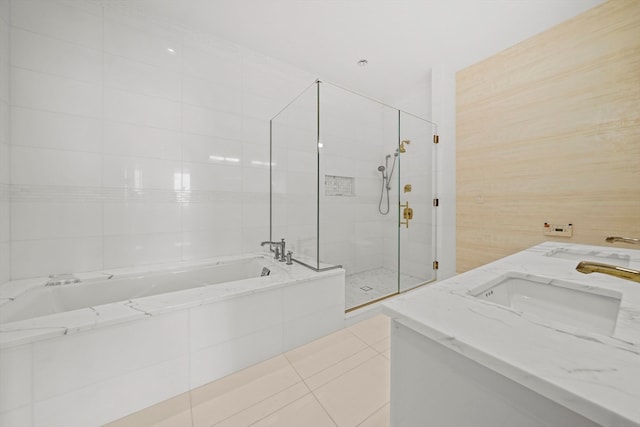 bathroom featuring independent shower and bath, tile walls, dual sinks, and tile floors