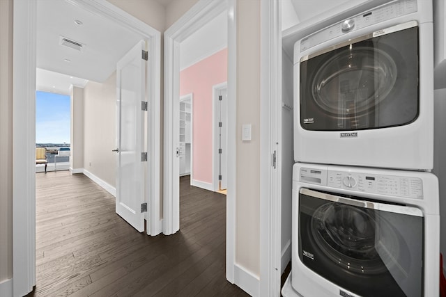 laundry area with stacked washer and clothes dryer and dark hardwood / wood-style floors