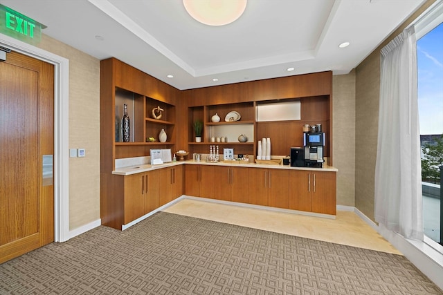 kitchen with built in features, built in desk, a healthy amount of sunlight, and a raised ceiling