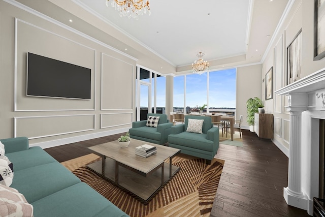 living room featuring dark hardwood / wood-style flooring, a notable chandelier, ornamental molding, and decorative columns