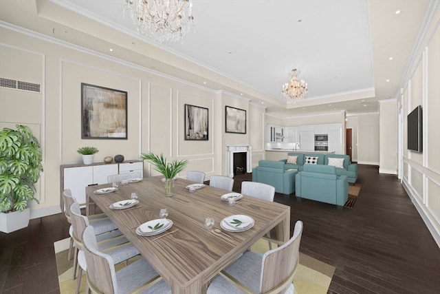 dining space featuring dark hardwood / wood-style flooring, crown molding, a notable chandelier, and a tray ceiling