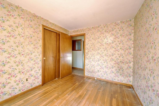 unfurnished room featuring baseboards and wood finished floors