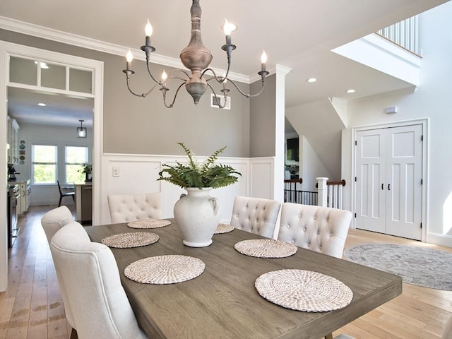 50 Bentley Ln, Westport, MA 02790 - dining space featuring light wood-type flooring, wainscoting, a chandelier, crown molding, and a decorative wall