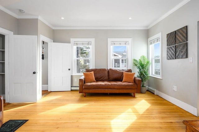 sitting room featuring ornamental molding, baseboard heating, light wood-type flooring, and baseboards