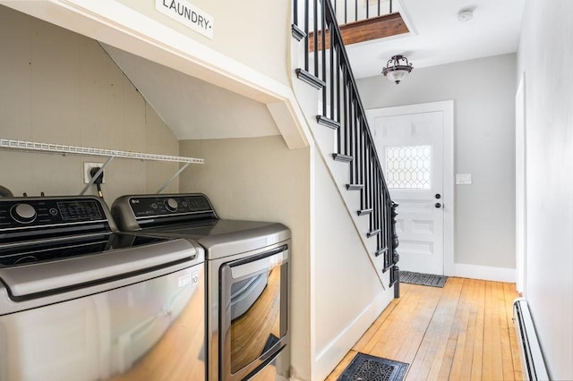 clothes washing area featuring laundry area, separate washer and dryer, visible vents, light wood-style floors, and baseboard heating