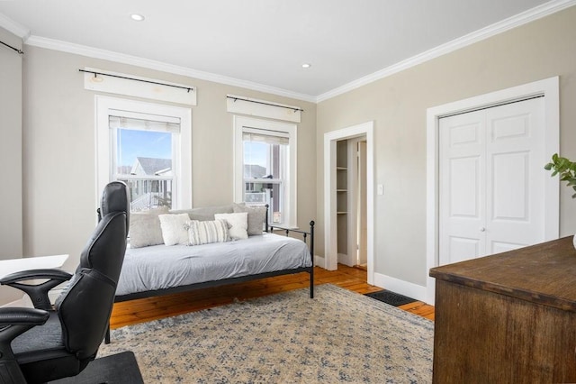 bedroom featuring baseboards, ornamental molding, wood finished floors, and recessed lighting