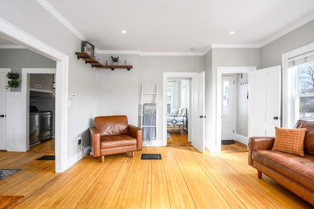 sitting room featuring light wood finished floors, baseboards, and ornamental molding