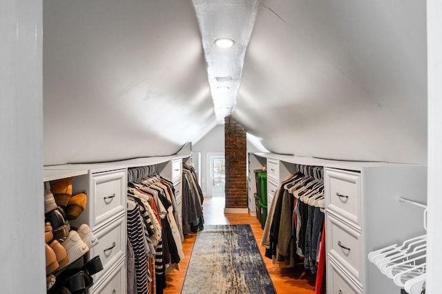 spacious closet with lofted ceiling and light wood-style flooring