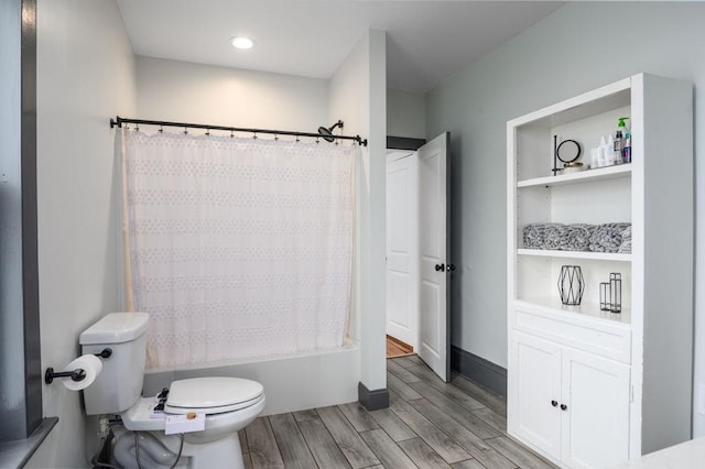 bathroom featuring shower / bath combination with curtain, baseboards, toilet, and wood finished floors