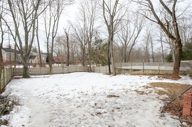 yard layered in snow featuring a fenced backyard