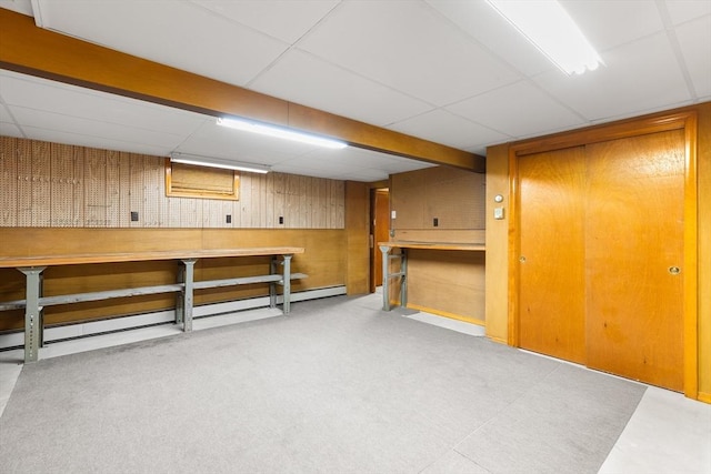 basement featuring a workshop area and a drop ceiling