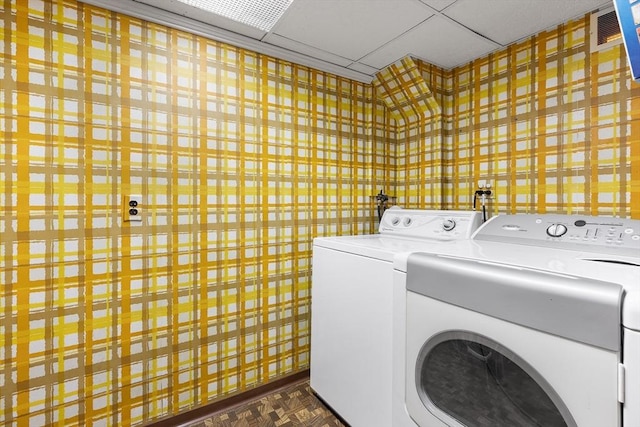 laundry room featuring dark parquet flooring and separate washer and dryer