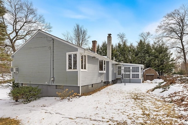 view of snowy exterior featuring a storage shed