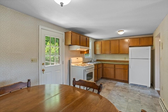 16 Winding Ln, Lowell, MA 01852 - kitchen featuring white appliances, under cabinet range hood, brown cabinets, and wallpapered walls