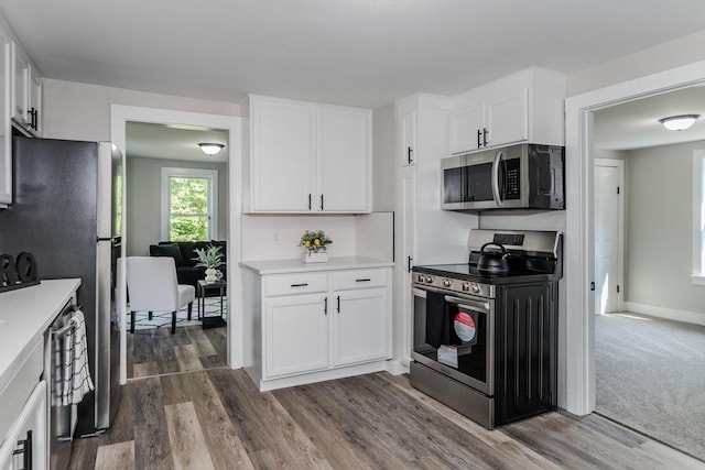 7 2nd Ave, Ware, MA 01082 - kitchen featuring appliances with stainless steel finishes, light countertops, white cabinets, and dark wood-style floors