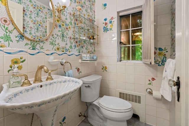 bathroom featuring tile walls, toilet, sink, tile patterned floors, and radiator heating unit