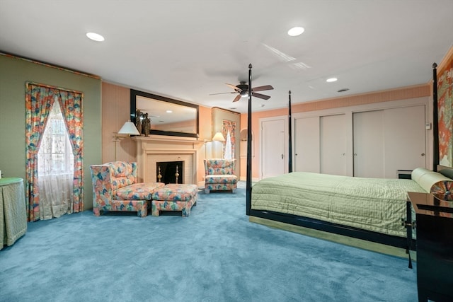 carpeted bedroom with ceiling fan and multiple closets