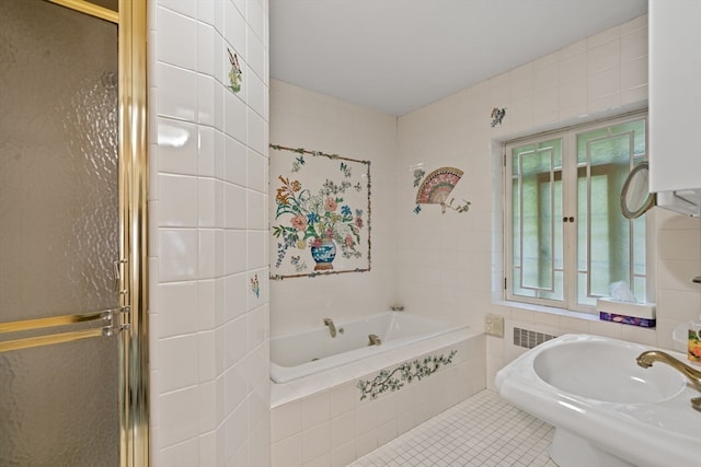 bathroom with tile walls, separate shower and tub, sink, and tile patterned flooring