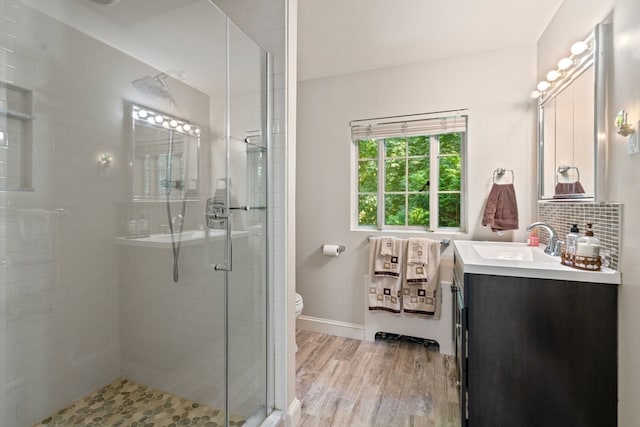 bathroom with vanity, toilet, hardwood / wood-style floors, and a shower with shower door