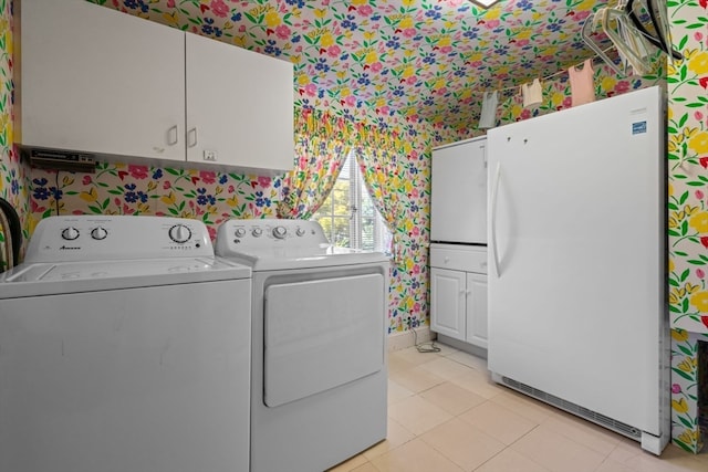 laundry room featuring cabinets, independent washer and dryer, and light tile patterned flooring