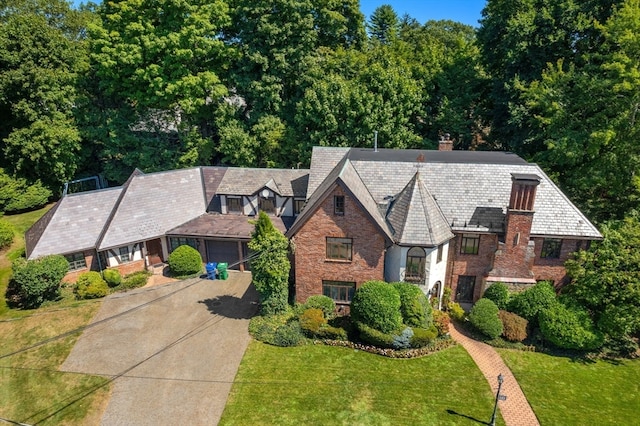 tudor-style house featuring a front lawn