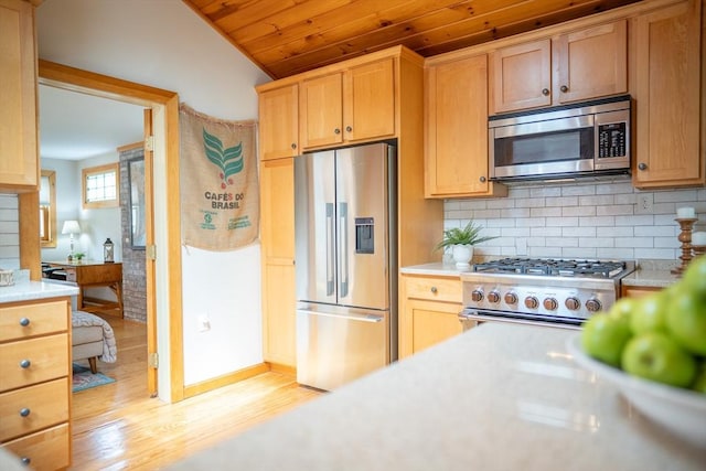 11 Cliff St, Dennis, MA 02638 - kitchen with appliances with stainless steel finishes, light countertops, light wood-style floors, tasteful backsplash, and vaulted ceiling