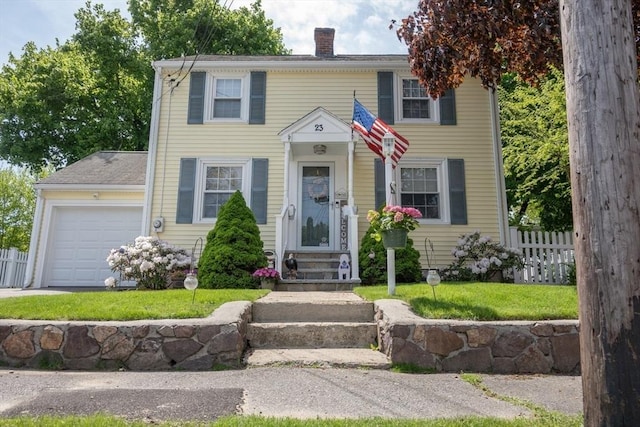 colonial inspired home with a garage and a front yard