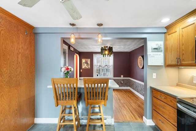 kitchen with decorative light fixtures, electric range oven, and dark tile patterned flooring