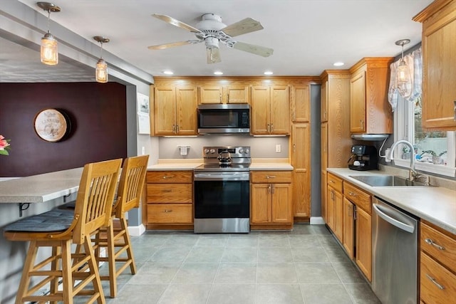 kitchen featuring sink, pendant lighting, ceiling fan, and appliances with stainless steel finishes