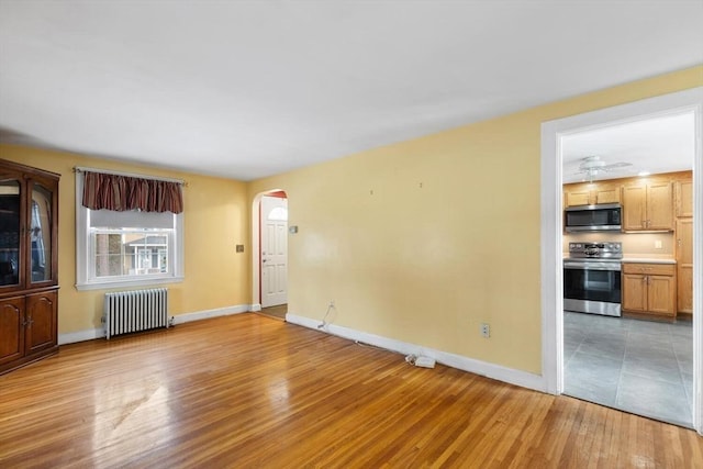 unfurnished living room featuring light hardwood / wood-style floors and radiator