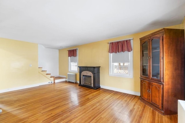 unfurnished living room with radiator and light hardwood / wood-style floors